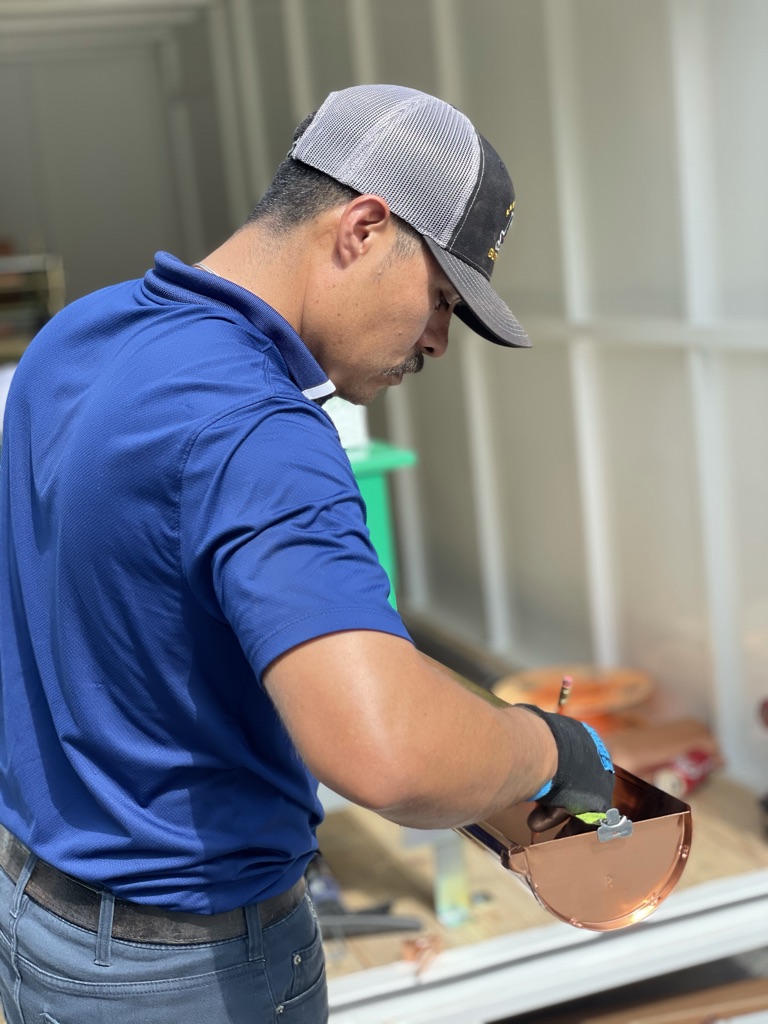 Technician repairing a damaged gutter section